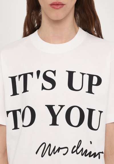 Vit bomulls t-shirt med svart text som säger "DET BEROENDE PÅ DIG" och en handskriven stil signatur längst ner.