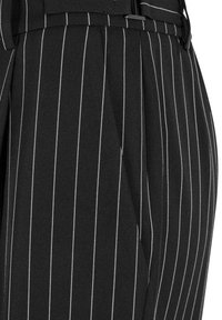 Pantalon en tissu noir avec fines rayures verticales blanches, avec une poche latérale et des passants pour ceinture à la taille.
