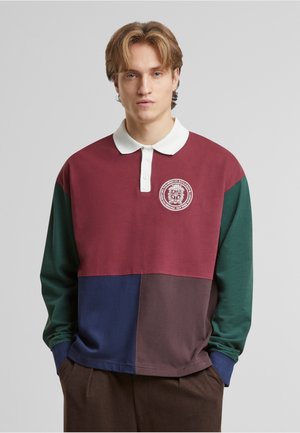 Long-sleeve polo shirt featuring a color block design in burgundy, green, navy, and brown. White collar with embroidered logo detail.