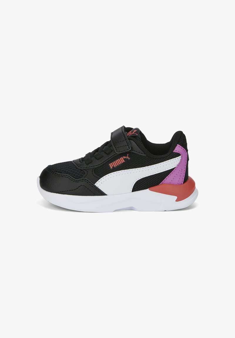 Baskets Puma noir et blanc avec des accents violets et rouges au niveau du talon, une bride velcro et une semelle blanche, vues de profil.