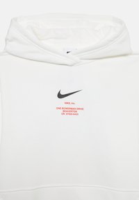 Hanorac alb din material moale. Caracterizat printr-un logo Nike negru și un text roșu cu informații despre companie pe față. Glugă ajustabilă.