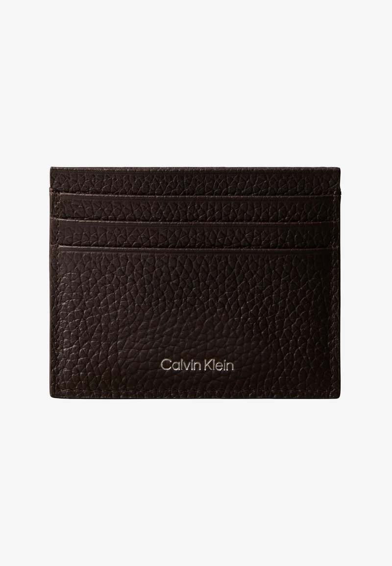 Porte-cartes en cuir texturé marron foncé avec trois emplacements pour cartes et logo Calvin Klein embossé en argent sur le devant.