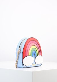 Vaaleansininen käsilaukku, joka on muotoiltu kuten sateenkaari, jossa on punaisia, vaaleanpunaisia, keltaisia, vihreitä ja sinisiä kaaria sekä kaksi valkoista pilvimuotoa alaosassa, kultaketjuolkaimet.