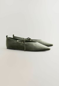 Velvet, olivengrønne flade sko med spids tå og indviklet snøredetalje. Glat tekstur og minimalistisk design. Flad gummisål.