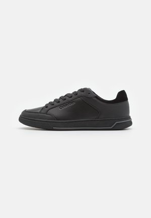 Schwarze Sneaker mit niedrigem Schaft aus glattem Leder, ausgestattet mit Schnürverschluss, gepolstertem Kragen und profillierter Gummisohle. Dezentes Markenlogo.