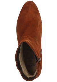 Väri ruskearuokoinen nilkkuri, jossa on sileä pinta, pyöristetty kärki, sivuzippi kiinnitys ja pehmeä sisävuori mukavuutta varten.