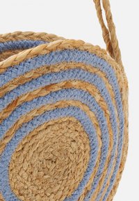 Rund vävd korg med naturligt halm och blå tygremsor, strukturerad yta och ett flätat handtag för bärande.