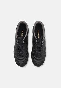 Schwarze Leder-Sportschuhe mit glatter Textur, runder Zehenform, einfarbigen Schnürsenkeln und einem grauen Kragen. Logo-Detail sichtbar auf der Zunge.