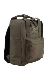 Zaino verde oliva realizzato in tessuto resistente, con parte superiore arrotondata, compartimenti con cerniera e una toppa circolare con logo sulla parte anteriore.