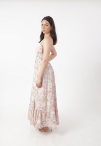 Robe maxi fleurie avec des motifs de roses roses et bleues, bretelles ajustables, corsage froncé et ourlet à volants, fabriquée en tissu léger.