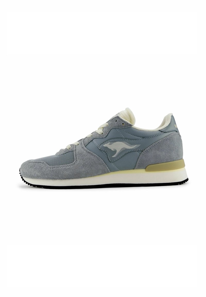 Scarpa sportiva grigia realizzata in materiali scamosciati e in rete, con punta tonda, chiusura con lacci, intersuola bianca e suola esterna in gomma nera testurizzata.