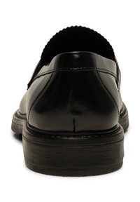 Svarta läder loafers med en slät, blank yta, rund tå och platt gummisula. Har en upphöjd, scallop-design på hältrimmet för detaljer.