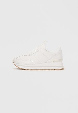 Sneaker bianca bassa con lacci, suola ammortizzata e suola in gomma beige su sfondo semplice.