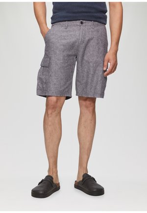 Shorts cargo gris en tissu texturé, avec poches latérales et fermeture à bouton. Portés avec des chaussures noires à enfiler.