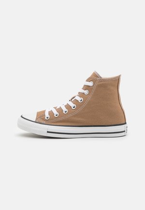 Baskets montantes en toile marron avec lacets blancs, bout en caoutchouc blanc et semelle blanche avec des bandes noires, vues de profil.