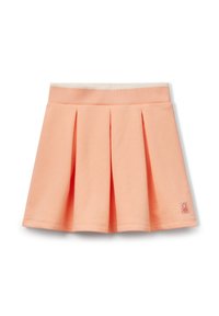 Perzikkleurige plissérok van zacht materiaal, met een brede elastische tailleband en een klein logo-opdruk aan de zijkant. Glad textuur.