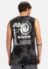 Black tie-dye sleeveless shirt features white graphics of a figure with a trumpet, a swirling design, and stylized accent details.