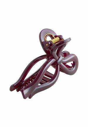 Lila Kunststoffhaarklammer mit geschwungenem Design, ausgestattet mit einem goldenen Federmechanismus und mehreren Greifzähnen für einen sicheren Halt der Haare.