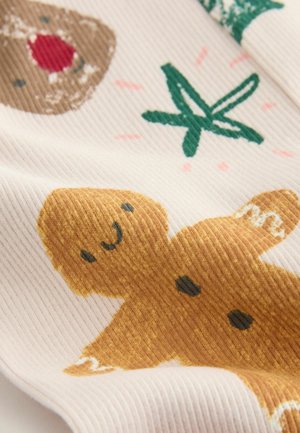 Baumwollstoff mit einem Design von Lebkuchenmann, der ein lächelndes Gesicht hat, in hellbrauner Farbe und mit gerippter Struktur, akzentuiert durch grüne Blätter und kleine pinkfarbene Details.