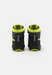 Schwarze und neongrüne Mid-Top-Sneaker mit gepolstertem Kragen, strukturierten Einsätzen, reflektierenden Akzenten und robuster Gummisohle.