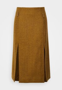 Brun chevronmönstrad kjol med knälång design, som har två sidoöppningar och en mjuk textur. Minimal hårdvara med diskreta sömnadsdetaljer.