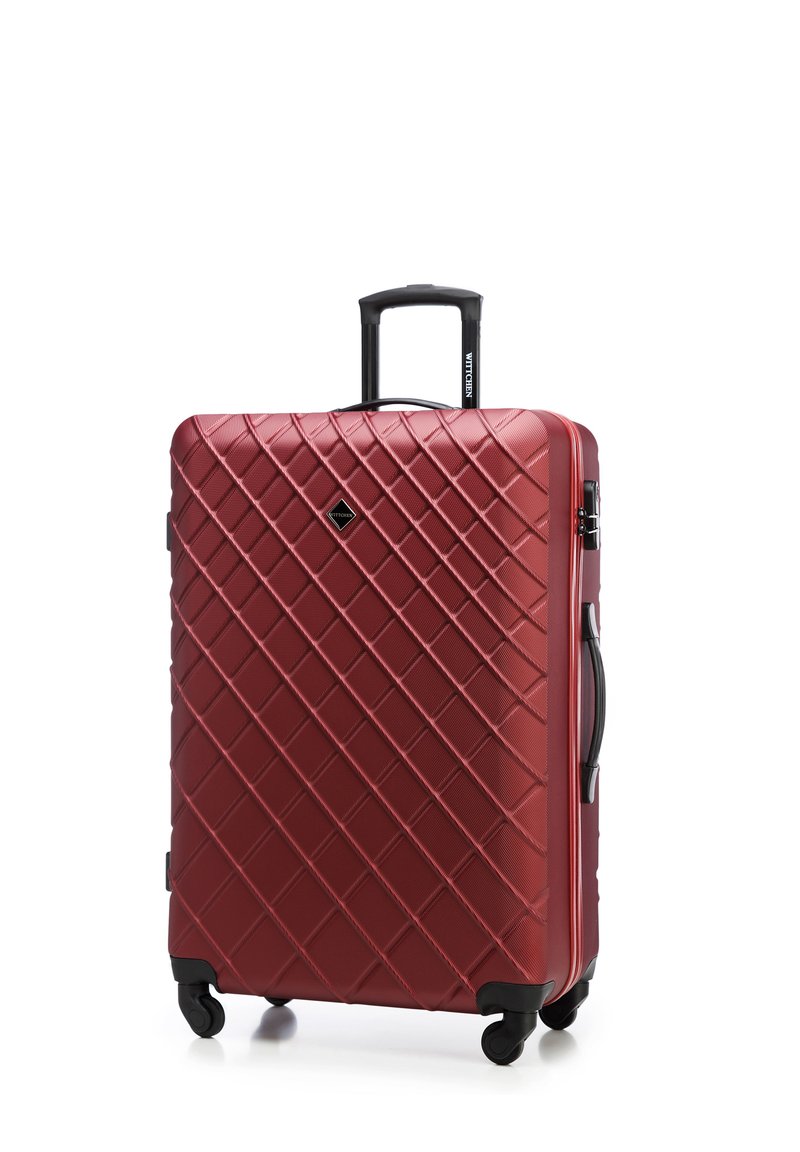 Valigia rigida rossa con texture a motivo diamante, due ruote nere, manico estensibile e una maniglia superiore per un facile trasporto.