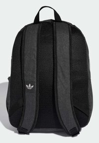 Črn nahrbtnik z mrežnim zadnjim delom, debelimi oblazinjenimi naramnicami in majhno belo logotipno značko. Trpežen material z teksturnimi poudarki.