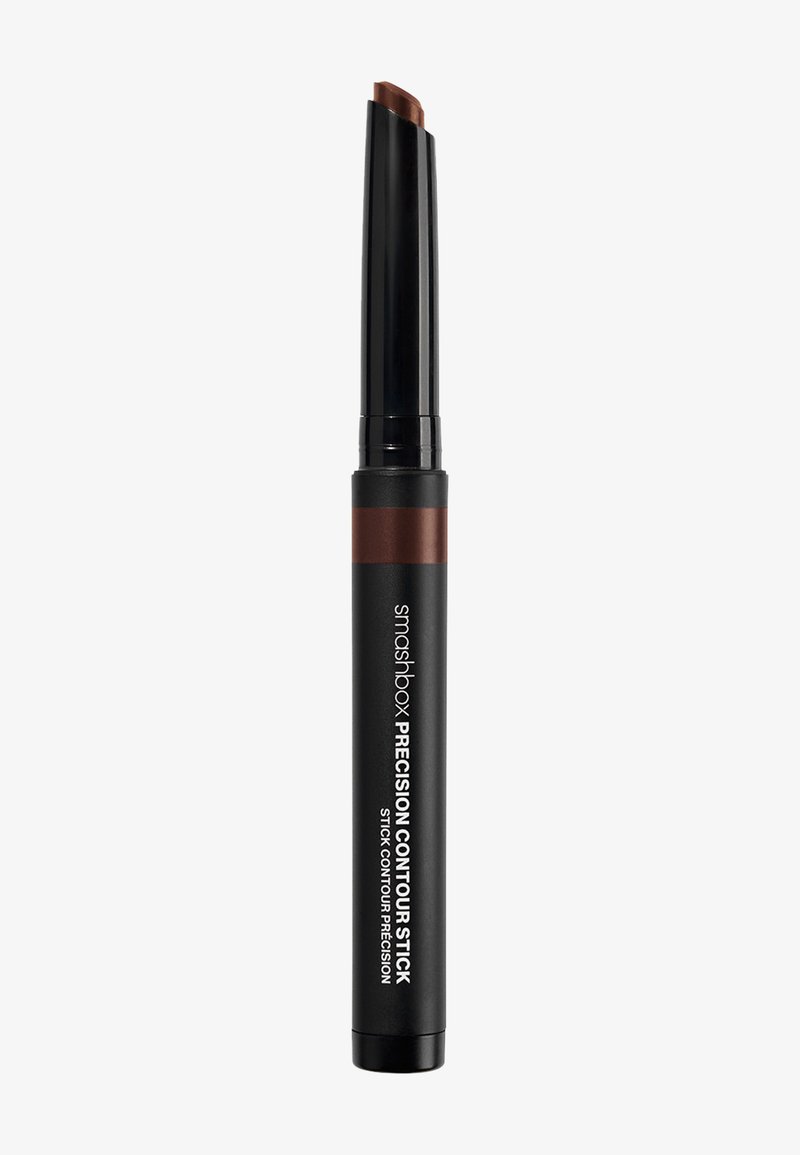 Black cylindrical contour stick with a rounded tip, featuring a brown shade at the top. Printed white text on the side indicates the brand and product name.