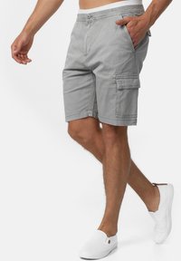 Shorts cargo gris à coupe décontractée, dotés de poches latérales et d'une fermeture à bouton. Confectionnés en tissu léger, idéaux pour une tenue décontractée.