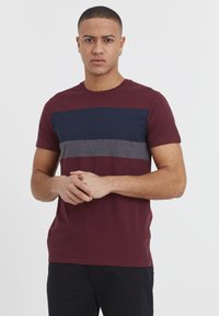 Bordeaux T-shirt med marineblå og grå vandrette striber. Korte ærmer, rund halsudskæring og et enkelt design. Blødt bomuldsstof.