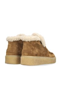 Brown suede ankle boots featuring a fluffy cream collar, a thick textured sole, and decorative stitching on the front.