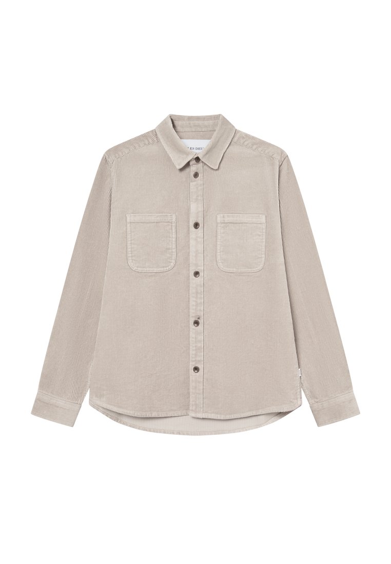 Beige kordflorskjorta med långa ärmar, krage, två bröstfickor och rundad nederkant. Knappstängning och texturerad tyg.