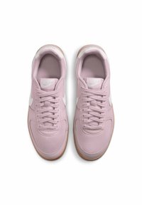 Ljusrosa träningsskor med vita accenter, med en slät tygöverdel, rund tå och gummisula. Snörena är symmetriska.