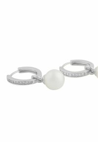 Silver hoops med en stor vit pärla och en rad små klara ädelstenar längs framsidan av hängena.