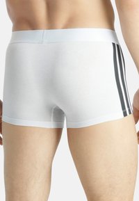 Vita bomullsboxer med svart rand i sidan, med en slät midja och snug passform.