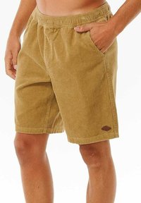Khaki-Corduroy-Shorts mit elastischem Bund, seitlichen Taschen und einem Logo-Patch am Saum. Texturiertes Material und mittellanges Design.