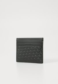 Svart lær kortholder med preget geometrisk mønster, med tre kortspor og en glatt toppkant. Kompakt, rektangulær form.