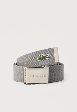 Grijze stoffen riem met een zilveren gesp gegraveerd met "LACOSTE" en geborduurd groen krokodillenlogo aan het uiteinde van de band.