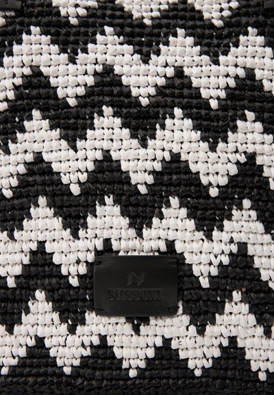 Μαύρη και άσπρη υφαντή τσάντα με ζιγκ-ζαγκ σχέδιο, κατασκευασμένη από υλικό με υφή, με καφέ δερμάτινη ετικέτα με ανάγλυφο το "Missoni."