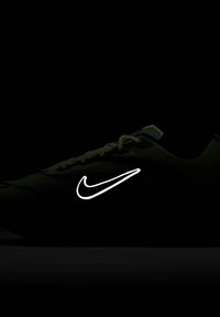 Nike hardloopschoen in levendig groen met een gestructureerd bovenwerk, voorzien van zwarte accenten en een opvallend wit Swoosh-logo.