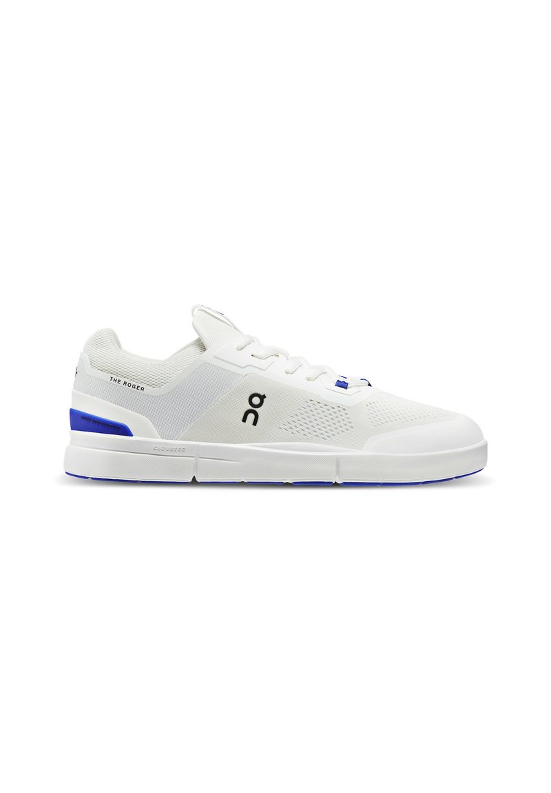Zapatilla deportiva blanca con parte superior de malla, acentos azules y logo. Presenta una superficie texturizada y una suela acolchada para soporte y comodidad.