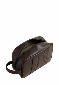 Trousse de toilette en cuir marron avec un motif à carreaux d'un côté, fermeture éclair et poignée de transport. Surface texturée, forme compacte.