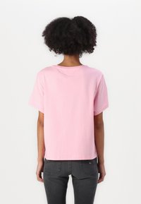 Rosa bomulls t-skjorte med korte ermer og en avslappet passform, med rund hals og rett kant. Enkel design, ingen mønstre eller utsmykninger.