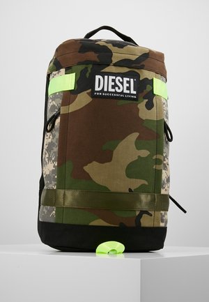 Mochila con patrón de camuflaje, base negra, correas verde neón, asa negra y parche con el logo "DIESEL For Successful Living" en el frente.