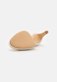 Scarpa slip-on beige con tomaia morbida, punta a mandorla, suola texturizzata color tan e design minimalista. Tacco piatto e senza dettagli visibili.
