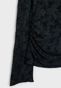 Schwarzer, floral bestickter Stoff mit weicher Textur, gerafften Details und einem fließenden Fall am Saum.