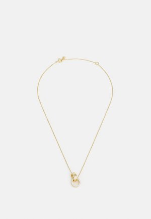 Gul kedja halsband med en cirkulär pendant prydd med små klara kristaller, mot en enhetlig vit bakgrund.