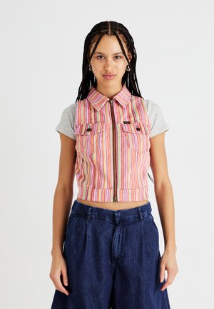 Rutet, kort vest med glidelås foran, rosa og multicolor stoff, to brystlommer, brukt over en grå topp med korte ermer, sammen med mørk denim.