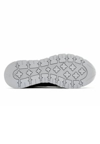 Semelle de chaussure de sport noire avec une semelle extérieure en caoutchouc blanc texturé, présentant un motif de traction détaillé composé de triangles et de formes rectangulaires.