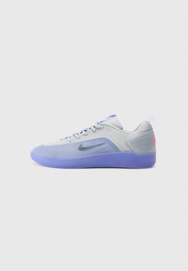 Grey athletic shoe with a smooth texture, purple sole, black logo, and light blue accents. Features lace-up front and padded collar.
